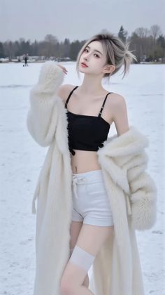 Woman in a white fur coat, black crop top, and white shorts in a snowy field
