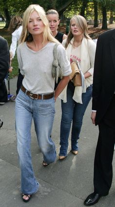 Blonde woman in a t-shirt and jeans walking outdoors with other people