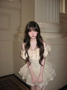 Woman with long dark hair wearing an off-shoulder dress with a large bow