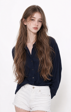 Woman with long brown hair wearing a navy shirt and white shorts in a studio