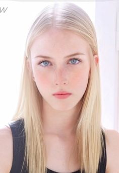 Young woman with blonde hair and blue eyes looking directly at the viewer