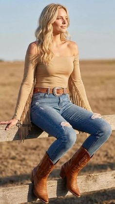 Woman with blonde hair wearing an off-shoulder top, ripped jeans, and cowboy boots
