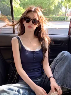 Woman with long hair and sunglasses in a blue tank top inside a car