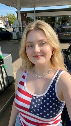 Blonde woman in an American flag print tank top at a gas station
