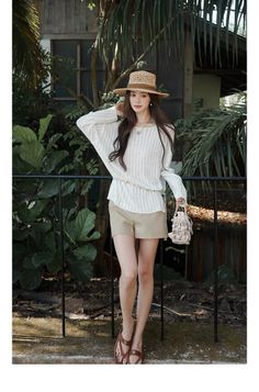 Woman in a straw hat and khaki shorts posing outdoors