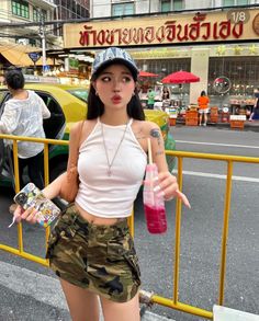 Woman in a camouflage skirt and white crop top on a street
