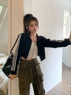 Woman in a black jacket and cargo pants with headphones on