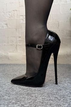 Leg in black stockings and patent leather high heels with an ankle strap