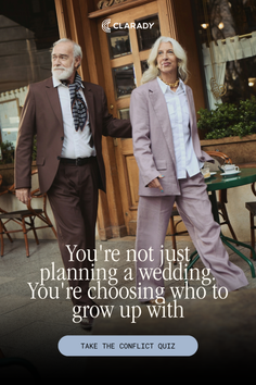 An older couple walking past an outdoor cafe, both dressed in suits
