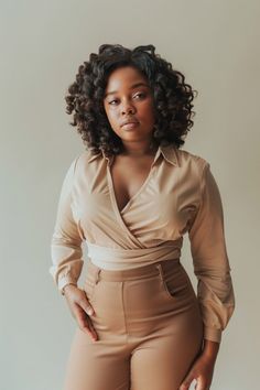 Woman with curly hair wearing a wrap shirt and high-waisted pants