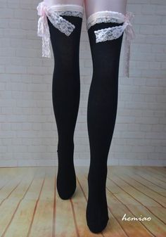 Pair of black thigh-high stockings with lace trim and pink bows