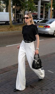 Woman in white pants and a black t-shirt walking on a street