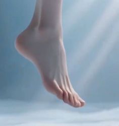 A bare foot against a light blue background with sun rays