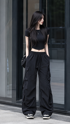 Woman with long black hair wearing a black crop top and cargo pants outdoors