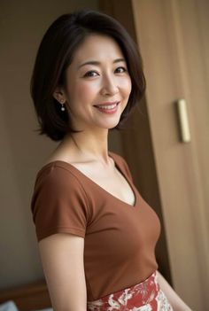 Woman with short hair and a brown top smiling indoors