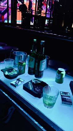 Table with drinks and cigarettes in a dark nightclub with neon lighting