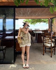 Woman in a straw hat and white shorts at a beachside resort