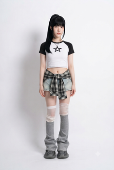 Woman with black hair in a ponytail wearing a crop top and denim shorts
