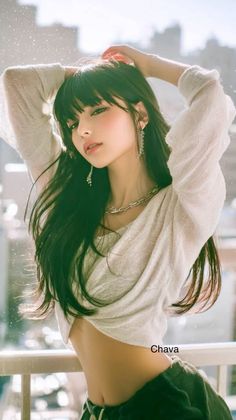 Woman with long dark hair and a crop top posing outdoors with soft lighting