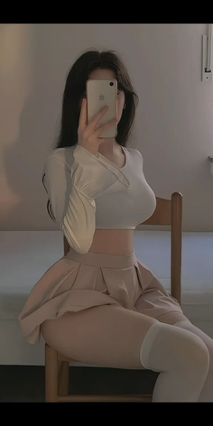 Illustration of a woman in a crop top and pleated skirt taking a mirror selfie