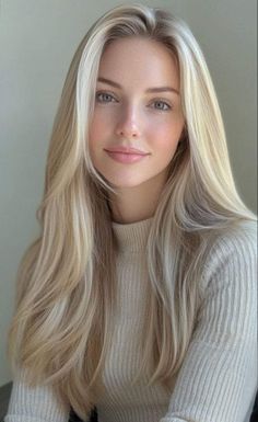 Woman with long blonde hair and green eyes wearing a light-colored sweater