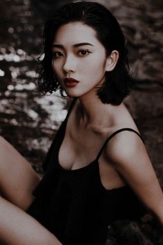 Woman with short black hair and red lipstick wearing a black top
