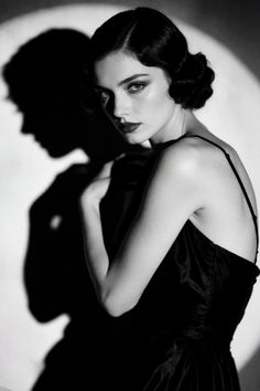 Woman in a black dress with a vintage hairstyle in dramatic black and white lighting