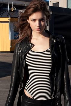 Woman in a leather jacket and striped top outdoors