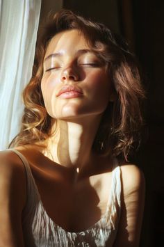 Woman with closed eyes in a white tank top, lit by dramatic window light
