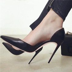Person wearing black high heels and black jeans with zipper detail