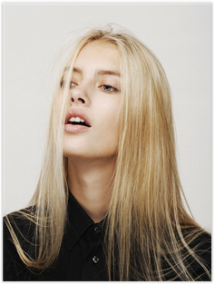Woman with long blonde hair and a black shirt looking upwards