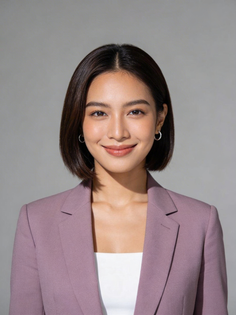 Woman with short hair wearing a purple blazer and white top in a studio