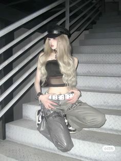 Woman with long blonde hair and a black tube top sitting on metal stairs