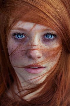 Close up portrait of a person with red hair and blue eyes