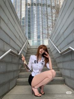 Woman in a white shirt and black shorts posing on outdoor stairs