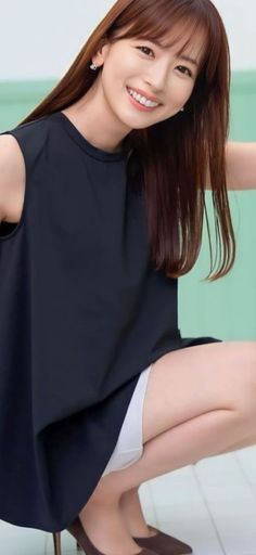 Woman in a black top and white shorts smiling in an indoor setting