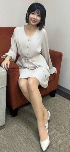 Woman with short hair and a light dress sitting on an orange armchair