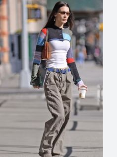 Woman in a colorful cropped cardigan and cargo pants walking on a street