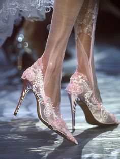 Close up of pink lace high heels with sheer fabric and pointed toes