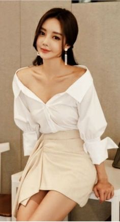 Woman in an off-shoulder white top and a beige mini skirt