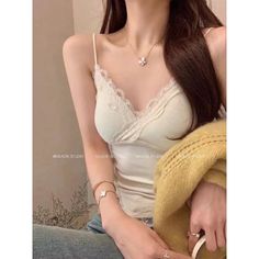 Woman wearing a white lace camisole and a necklace with a flower pendant