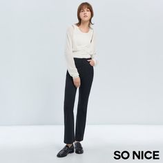 Woman in a white top and black pants posing in a studio
