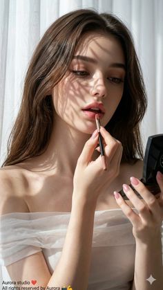 Woman with long hair applying lipstick in soft natural light indoors