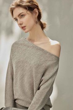 Woman in an off-shoulder sweater with a ponytail and earrings