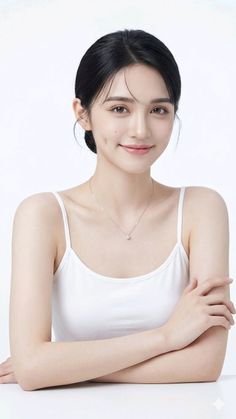 Woman with black hair in an updo wearing a white tank top and necklace
