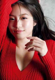 Woman in a red sweater with long dark hair, looking at the camera