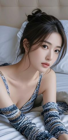 Woman with dark hair in a patterned top lying on a bed