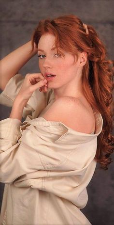Woman with red hair and freckles wearing an off-shoulder shirt