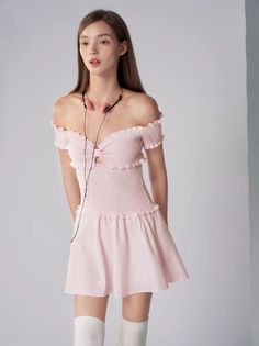 Woman in a pink off-shoulder dress and white socks with pink headphones
