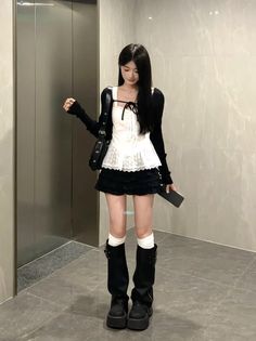 Woman with long black hair in a white lace top and black mini skirt indoors